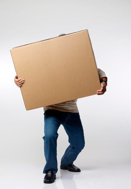 Homem de comprimento completo segurando uma caixa de papelão contra um fundo branco