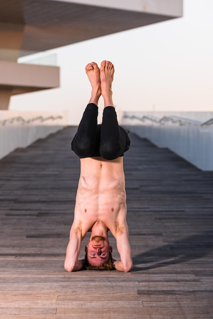 Foto homem de comprimento completo usando óculos de sol enquanto está de pé no chão de madeira