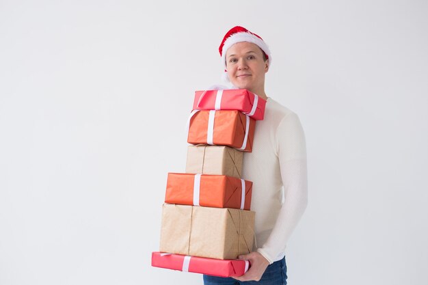 Homem de conceito de natal e feriados com chapéu de papai noel com muitos presentes em fundo branco com espaço de cópia