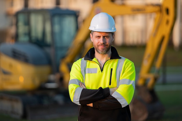 Homem de construção com escavadeira em local industrial Trabalhador em capacete com escavadeira Trabalho de engenheiro com empreiteiro construtor em capacete de segurança Capataz de escavação com trator Trabalhador com escavadeira