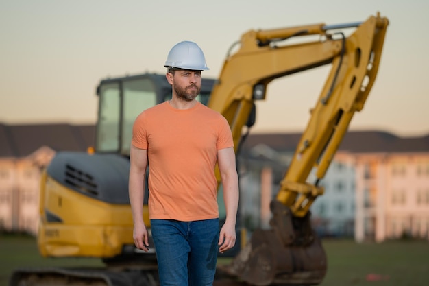 Homem de construção com escavadora em um local industrial Trabalhador de capacete com escavadeira Engenheiro wo