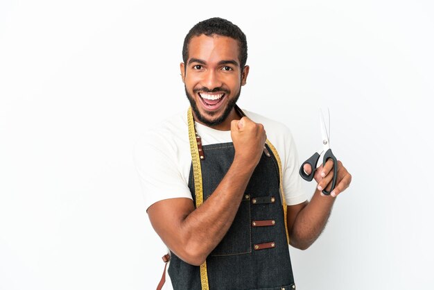 Homem de design equatoriano jovem segurando uma tesoura isolada no fundo branco comemorando uma vitória