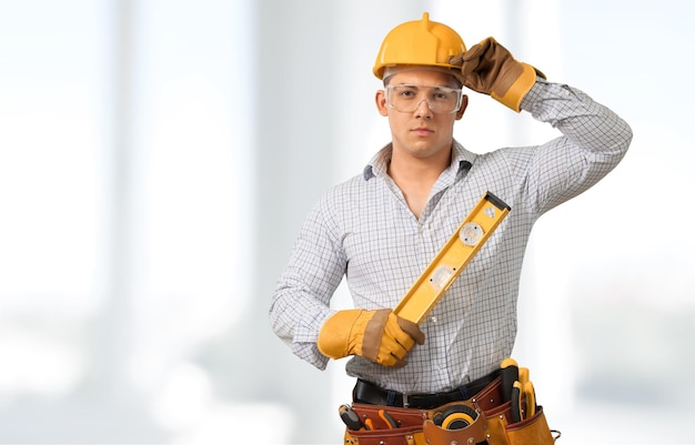 Homem de empreiteiro de carpinteiro usando óculos de segurança cinto de ferramentas isolado em branco