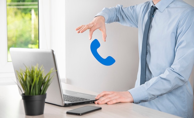 Homem de empresário segurar o ícone de telefone. ligue agora para o conceito de tecnologia de serviço ao cliente do centro de suporte de comunicação empresarial
