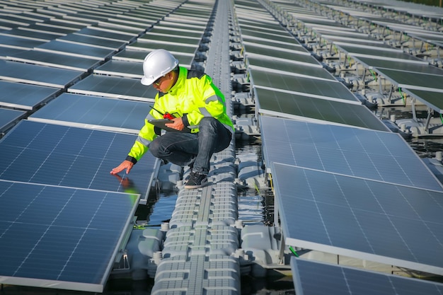 Homem de engenheiro trabalhando verificando os painéis de energia solar na bóia flutuando.