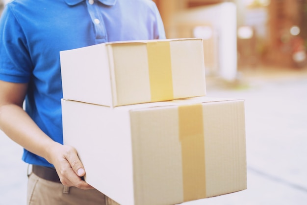 Homem de entrega de encomendas de um pacote através de um serviço de envio para casa. consign hand submission cliente aceitando uma entrega de caixas do entregador.