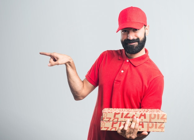 Homem de entrega de pizza apontando para o lateral