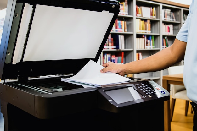 Homem de escritório a usar a fotocópia no local de trabalho do escritório