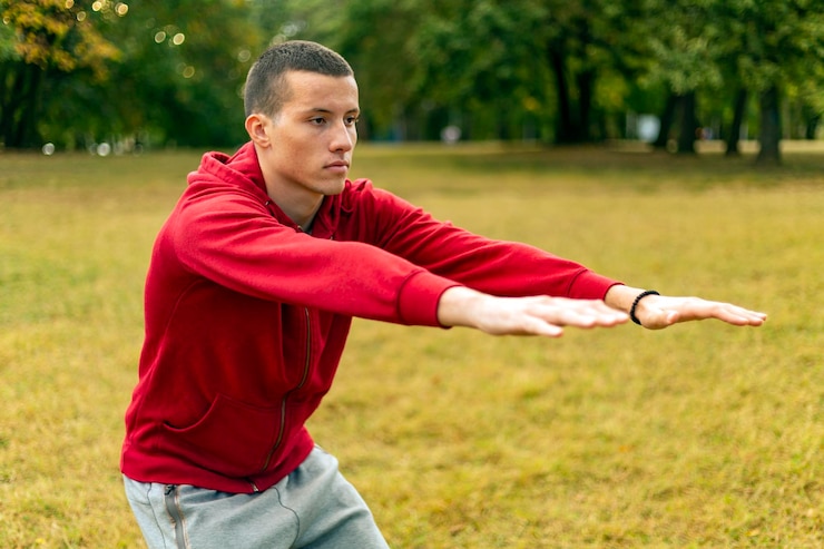 Foto homem de esporte se alongando no parque outono fazendo homem fazer exercícios de alongamento no parque outono