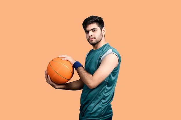 homem de esportes segurando basquete e olhando modelo paquistanês indiano frontal