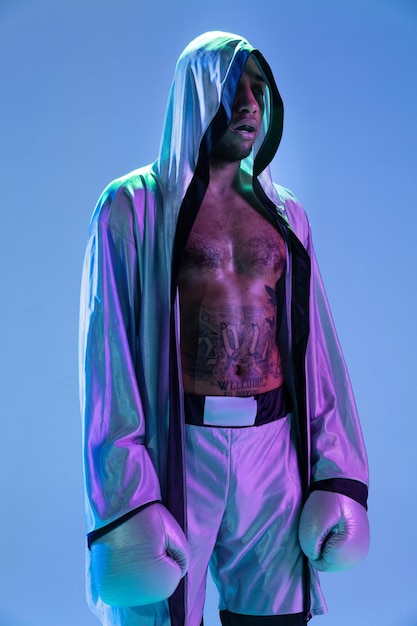 Homem de estilo highfashion em caixa de pacificação de roupa branca isolada sobre fundo gradiente em luz neon