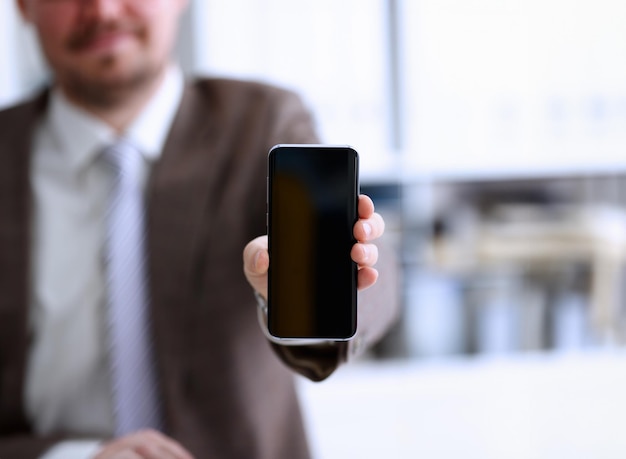 Foto homem de fato mostra o braço na câmera do telefone