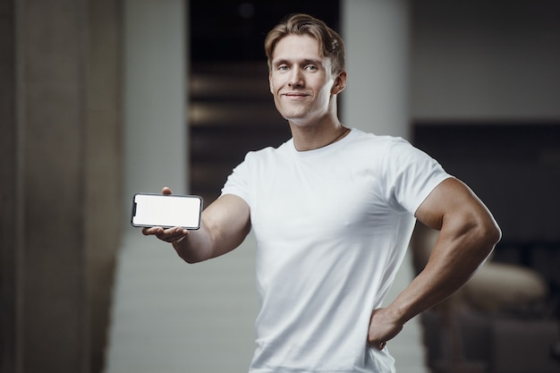 Homem de fitness na academia com telefone celular