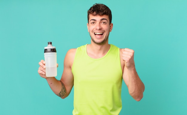 Homem de fitness se sentindo chocado, animado e feliz, rindo e comemorando o sucesso, dizendo uau!