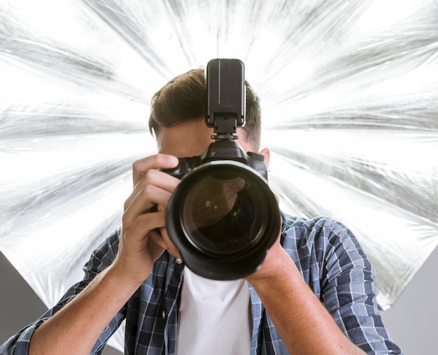Foto homem de fotógrafo segurando uma câmera profissional