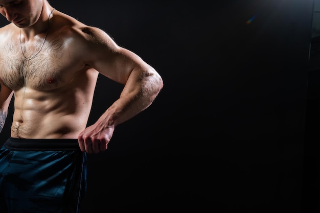 Homem de fundo preto mantém halteres bombeados no atleta de esporte de bíceps de musculação fitness