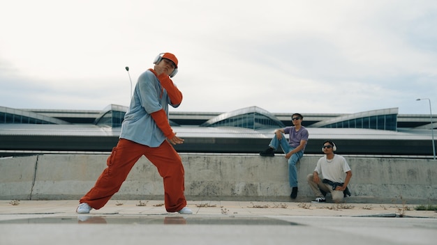 Homem de hip hop usando fones de ouvido enquanto posa na câmera com sprightly confiante