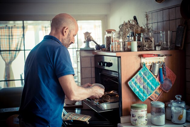 homem de idade miggle cozinhar