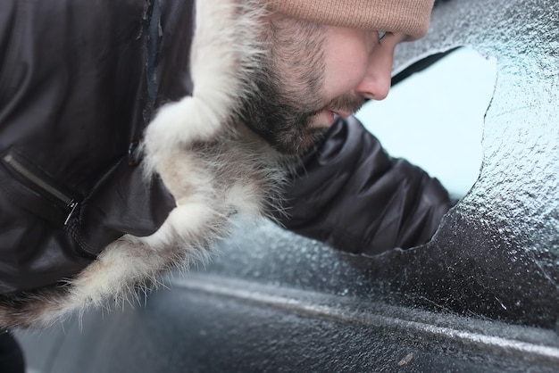 Homem de inverno vandalismo quebrou o vidro do carro uma pedrinha