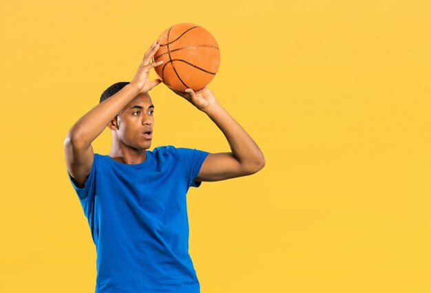 Homem de jogador de basquete afro-americano sobre amarelo