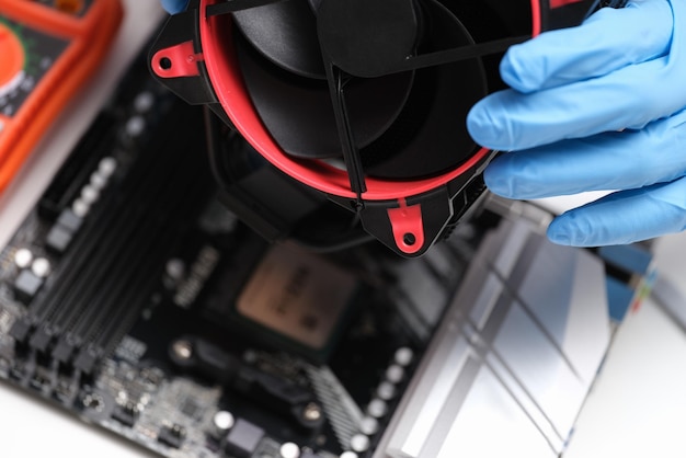 Homem de luvas brancas instalando ventilador de laptop