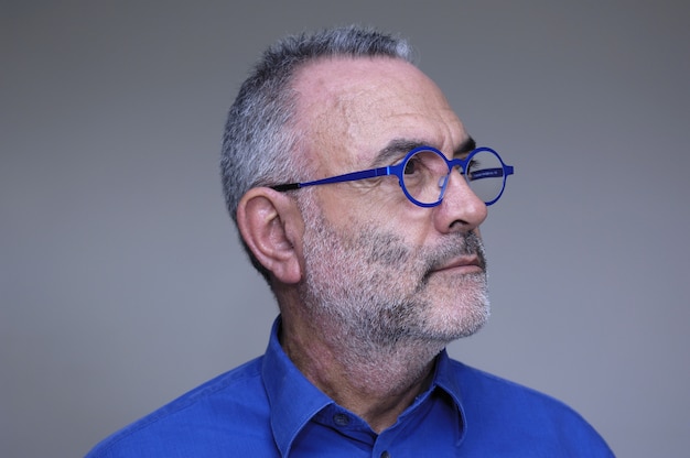 Homem de meia idade com camisa azul e óculos