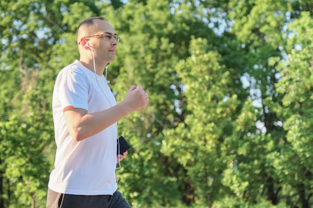 Homem de meia idade correndo no parque, estilo de vida saudável e ativo