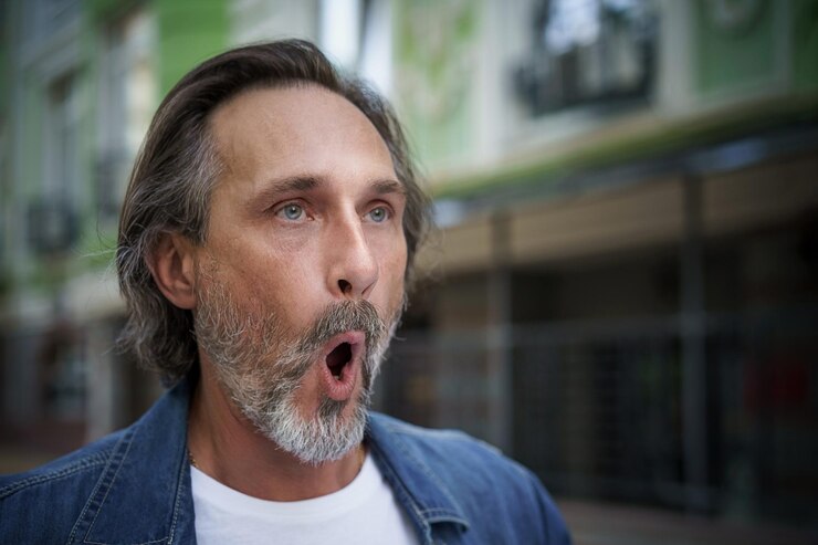 Foto homem de meia idade europeu exercício muscular facial ao ar livre na rua