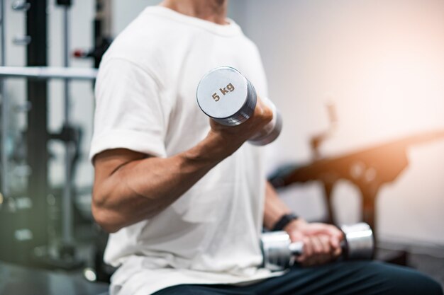 Homem de meia-idade fazendo treinamento muscular com halteres