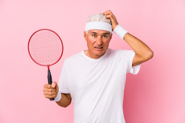 Homem de meia idade jogando badminton isolado sendo chocado, ela lembrou importante reunião.