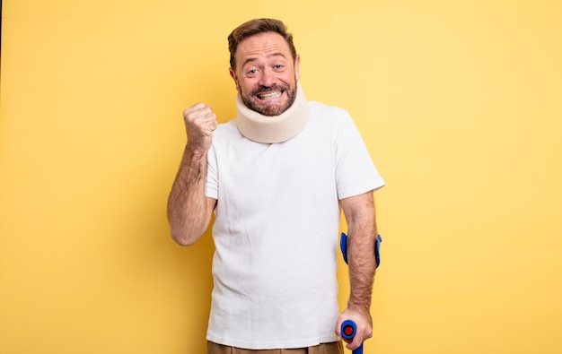 Foto homem de meia idade se sentindo chocado rindo e comemorando o conceito de acidente de sucesso ferido