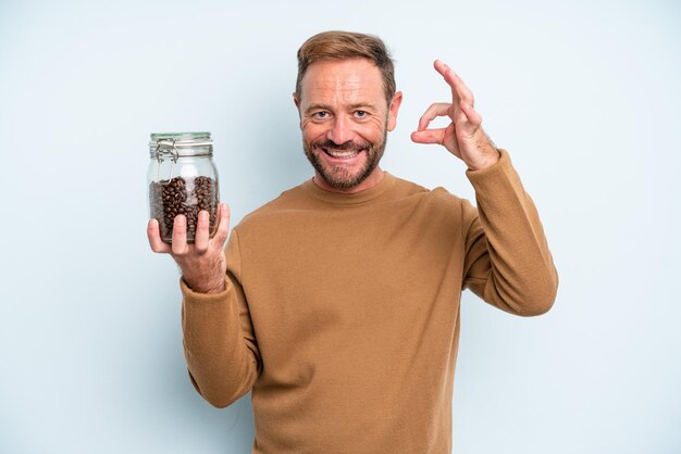 Homem de meia idade se sentindo feliz mostrando aprovação com o conceito de grãos de café de gesto bem