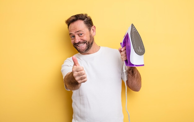 Homem de meia idade se sentindo orgulhoso, sorrindo positivamente com o polegar para cima. conceito de ferro de passar roupas