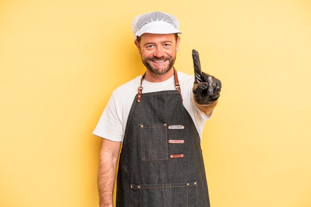 homem de meia idade sorrindo com orgulho e confiança fazendo o número um. conceito de peixeiro