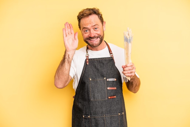 Homem de meia idade sorrindo e parecendo amigável, mostrando o artista número um com o conceito de pincéis