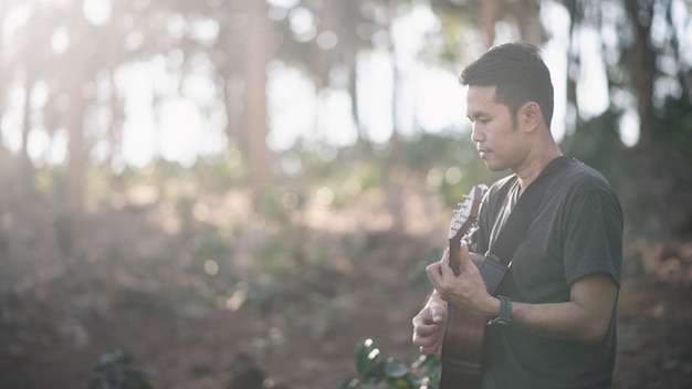 Homem de músico retrato com guitarra no forrest