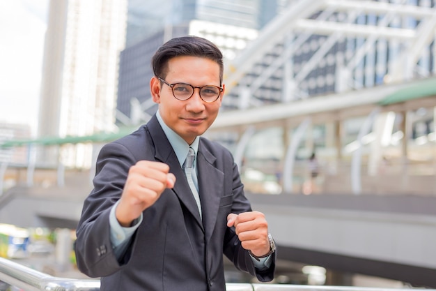 Homem de negócio novo de Ásia na posição de combate. Lutando por seu conceito de objetivos.