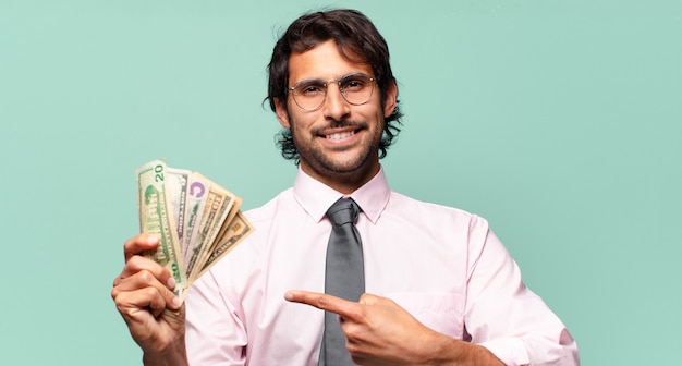 Homem de negócios adulto bonito indiano com notas de dólar