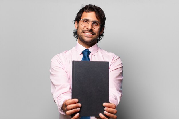 Homem de negócios adulto bonito indiano segurando um caderno