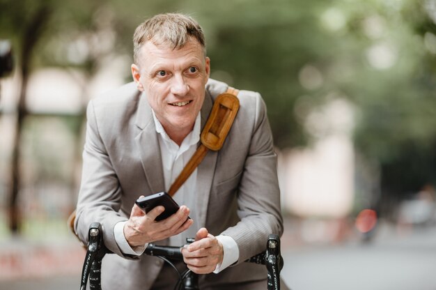 Homem de negócios adulto profissional, caucasiano, andar de bicicleta para o trabalho, bicicleta usando o estilo de vida fora do escritório moderno empresário usando smartphone móvel na rua no fundo urbano da cidade, conceito ecológico