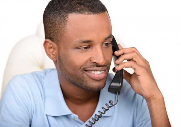 Homem de negócios africano novo que fala no telefone.