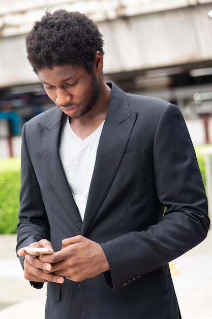 Homem de negócios africano usando aplicativo móvel para smartphone