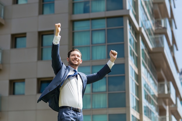 Homem de negócios alegre comemorando o sucesso ao ar livre