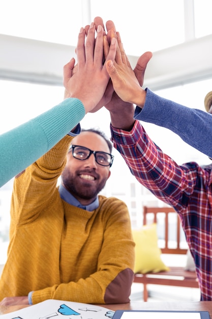 Foto homem de negócios alegre fazendo high five com equipe no escritório criativo