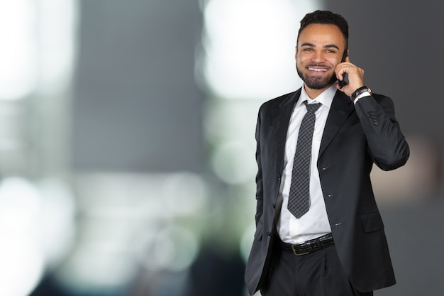 Homem de negócios americano africano usando telefone celular