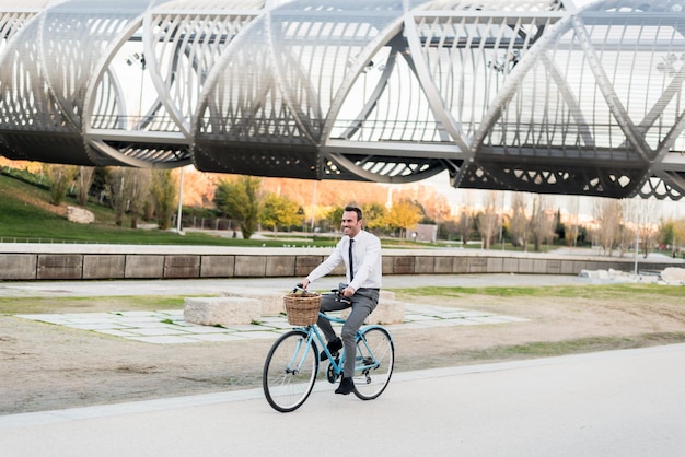 Homem de negócios andando de bicicleta vintage na cidade