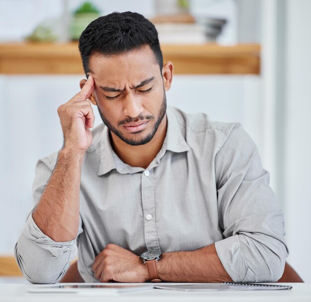 Homem de negócios asiático e escritório com dor de cabeça ou estresse com prazo e preocupação da empresa Empreendedor doente e frustrado com a carreira de startup e crescimento de emprego como designer de interiores e exausto