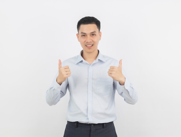 Homem de negócios asiáticos bonito jovem sorrindo e mostrando os polegares para cima isolado no fundo branco