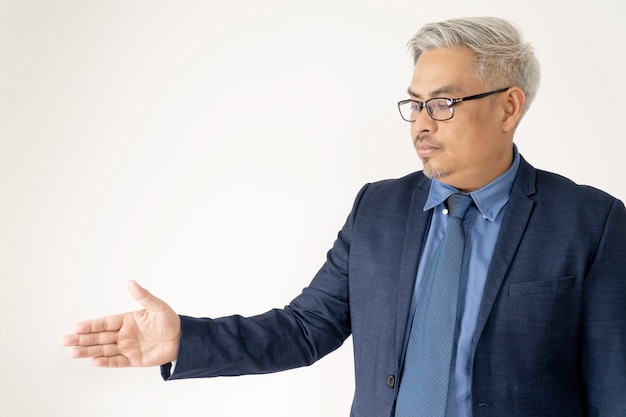 Homem de negócios asiáticos confiante retrato usando óculos e terno azul Handshaking em branco