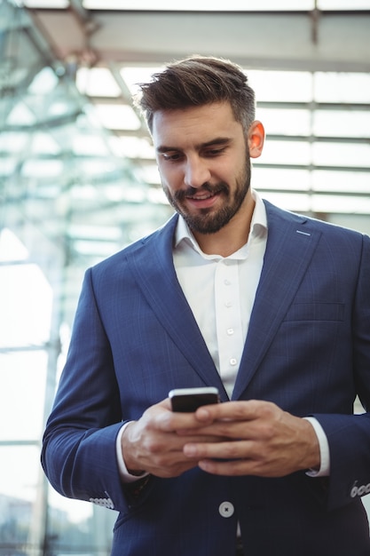 Homem de negócios atencioso usando telefone celular